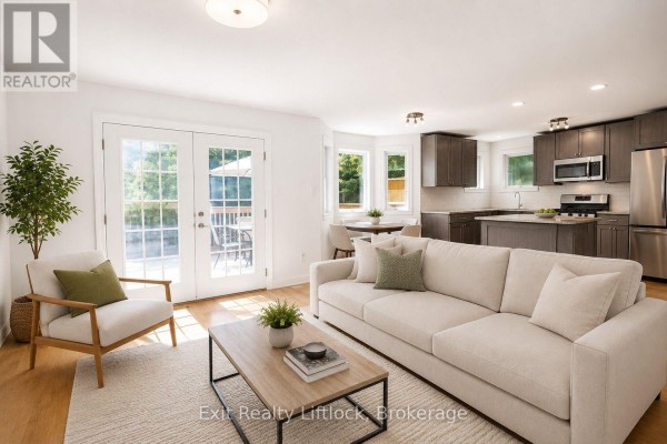 Living room with sofa, coffee table, and kitchen area with island - 3133 Frances Stewart Road Peterborough