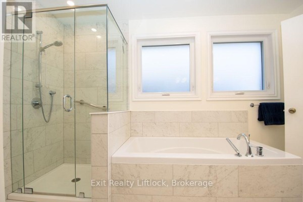 Bathroom with soaking tub, glass shower, and dual sinks - 3133 Frances Stewart Road Peterborough