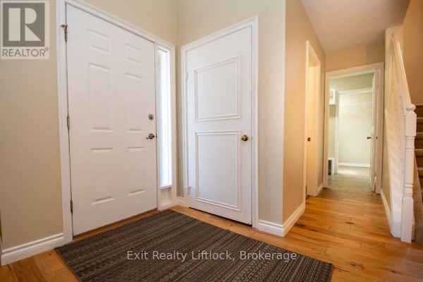 Entranceway inside a home with wood floors and doors to a hallway and closet. - 3133 Frances Stewart Road, Peterborough