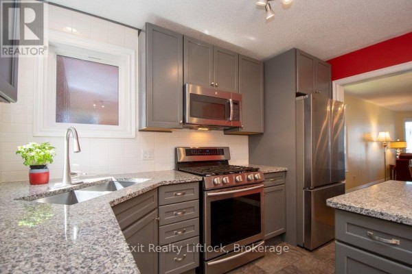 Modern kitchen with grey cabinets, granite counters, and stainless steel appliances - 3133 Frances Stewart Road Peterborough