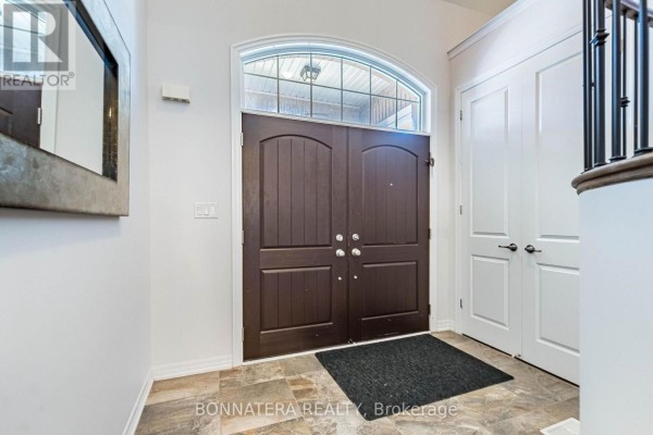 Interior view of foyer with dark brown double doors and arched window. - 3136 Ernest Appelbe Boulevard, Oakville