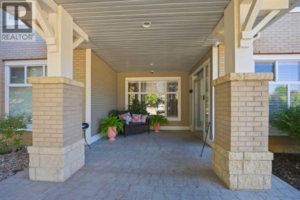 Covered entryway with stone pillars and seating. - 3137, 1010 Arbour Lake Road Nw, Calgary