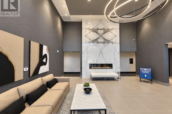 Lobby with a large marble fireplace, modern sofa, and abstract art. - 314 - 470 Gordon Krantz Avenue, Milton