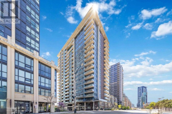 Exterior view of a modern high-rise apartment building with balconies under a blue sky. - 314 - 55 East Liberty Street, Toronto