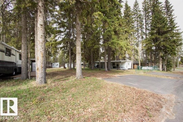 Roadway and grassy area with RVs and small buildings among trees. - #314 & 315 55230 Rge Rd 10, Rural Sturgeon County