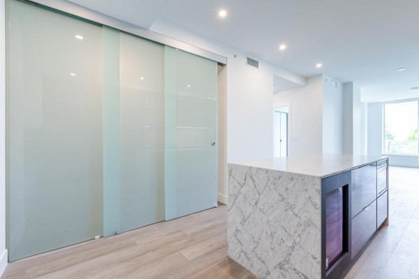 Home office with a desk, computer, office chair, and sliding glass door. - 314 1342 Johnston Street, White Rock