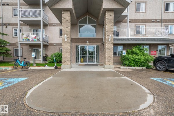 Apartment kitchen with light wood cabinets, white appliances, and entry door. - #314 240 Spruce Ridge Rd, Spruce Grove
