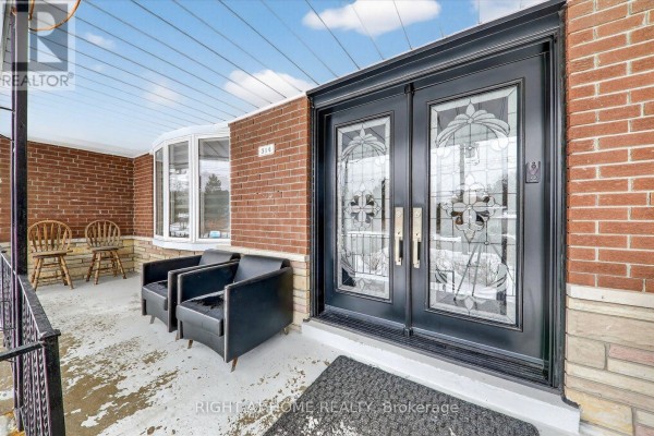 Covered front porch with black leather armchairs, wooden chairs, and a red brick exterior wall. - 314 Morrish Road S, Toronto