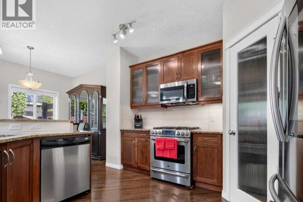 Two-story house with a double garage, stone accents, and a paved driveway. - 314 Reunion Heath Nw, Airdrie