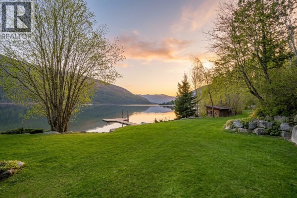Exterior view of log home with green siding, decks, and stairs. - 3140 3a Highway, Nelson