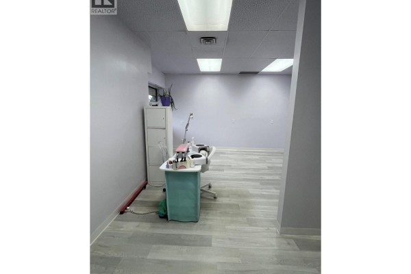 View of open room with nail station, grey floors, and white cabinets. - 3140 Lakeshore Road Unit# 203, Kelowna