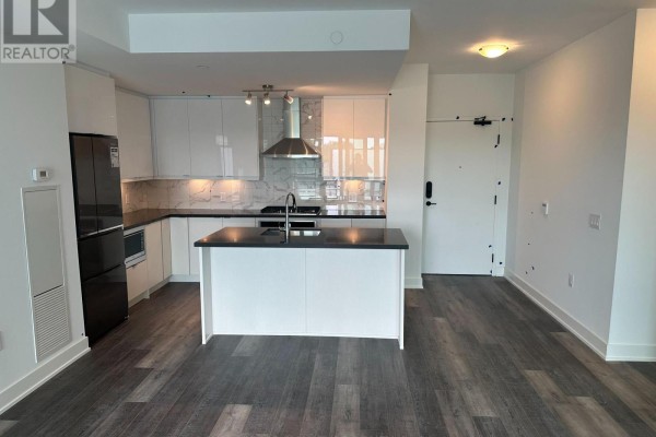 Open-concept living space with a white island kitchen and dark wood floors. - 314a - 11782 Ninth Line, Whitchurch Stouffville