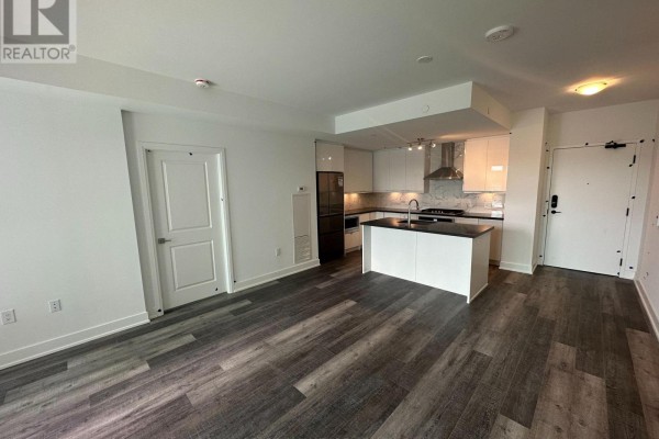 Living area and kitchen with white cabinets, island, and dark wood flooring. - 314a - 11782 Ninth Line, Whitchurch Stouffville