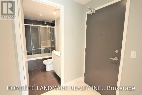 Hallway entrance of an apartment leading to a bathroom with a tub and toilet. - 315 - 1990 Bloor Street W, Toronto