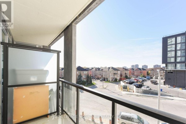 View from the balcony of a suburban street with houses, parked cars, and buildings. - 315 - 225 Malta Avenue, Brampton