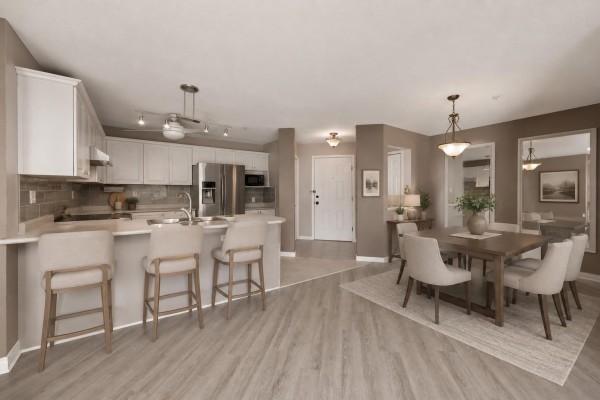 Open-concept kitchen and dining area with light wood floors, white cabinets, and beige chairs. - 315 22150 48 Avenue, Langley
