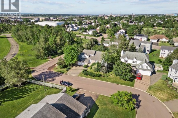 Aerial drone shot of Dieppe neighborhood with multiple houses and green trees. - 315 Belliveau, Dieppe