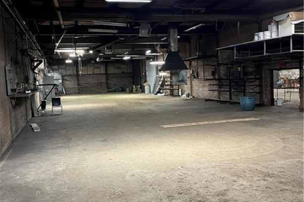 Interior view of a large, empty commercial space with concrete floors and overhead lighting. - 315 Brock Road Unit# B, Dundas
