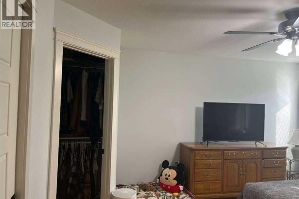 Bedroom with a closet, television on a dresser, and a ceiling fan. - 315 Centennial Avenue, Nobleford