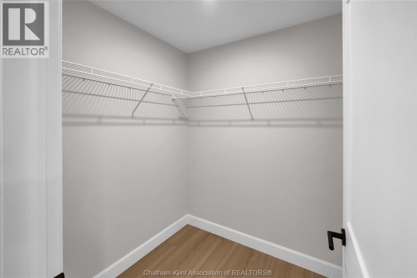 Walk-in closet with wire shelving and wood-look floors - 315 Ironwood Trail Chatham
