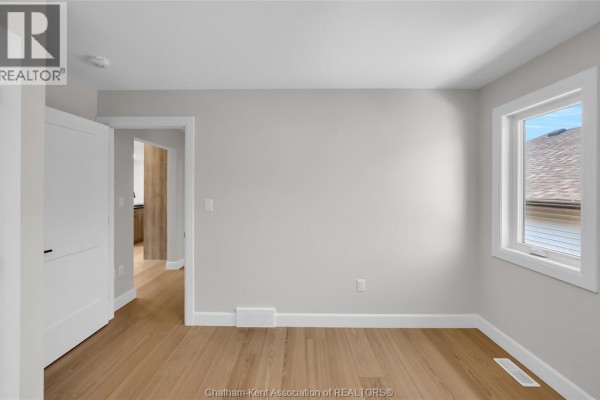 Hallway with hardwood floors and white doors - 315 Ironwood Trail Chatham