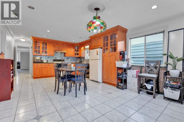 Spacious living area with large windows, hardwood flooring, and access to a balcony. - 3153 Parker Street, Vancouver