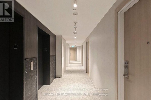 Interior hallway of a modern condo building with dark elevator doors and beige walls. - 316 - 1195 The Queensway St, Toronto