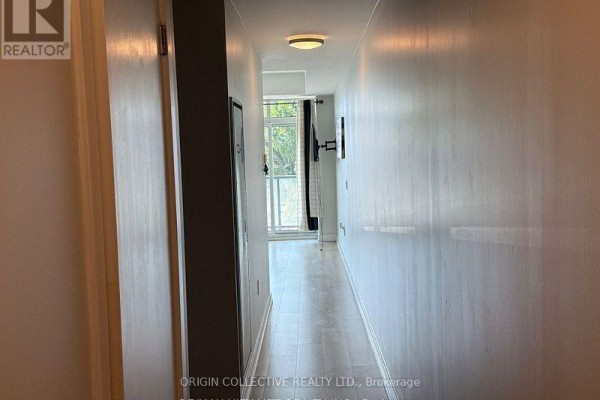 A bright hallway inside a condo unit leading to a balcony with sheer curtains. - 316 - 1195 The Queensway St, Toronto
