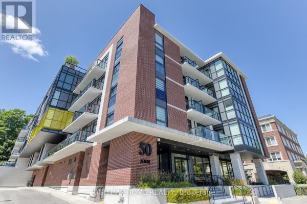Close-up of the modern brick and glass apartment building exterior with balconies and yellow accent. - 316 - 50 Ann Street, Caledon