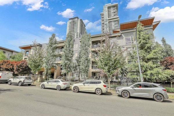 Living room with dark hardwood floors and large windows overlooking trees. - 316 13339 102a Avenue, Surrey