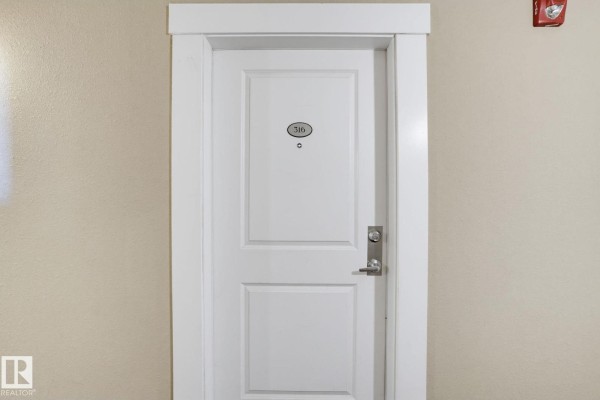 Interior apartment door with the number 316 and a silver handle against a beige wall. - #316 7711 71 St Nw, Edmonton