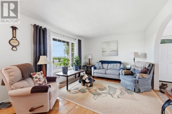 Living room with a large window, sofa, chairs, and patterned rug. - 3160 Dunning Road, Ottawa