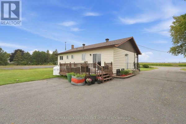 Cream house with wooden deck and propane tank - 3160 Dunning Road Ottawa
