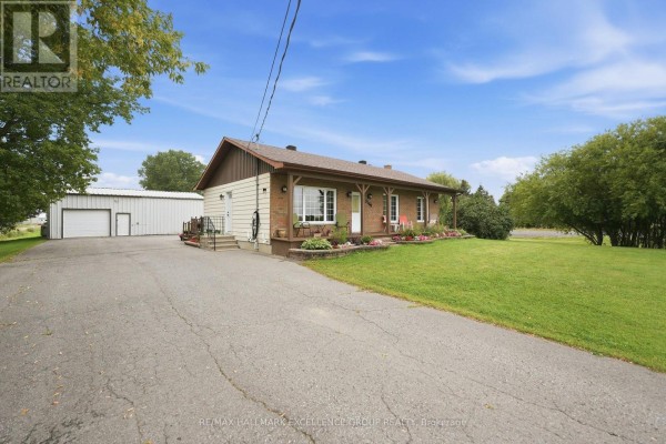 Brick bungalow with covered porch, flower beds and outbuilding - 3160 Dunning Road Ottawa