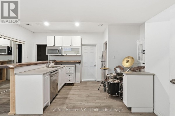 Kitchen with white cabinets, live edge bar, and drum set - 316040 6 Highway Chatsworth