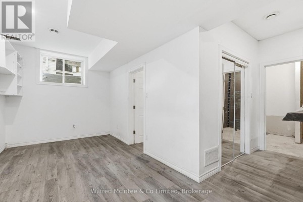 Basement room with wood-look flooring, mirrored closet doors, and a window - 316040 6 Highway Chatsworth