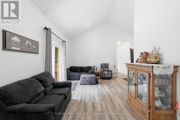 Living room with a vaulted ceiling, grey sofas, and a wood cabinet. - 316040 6 Highway, Chatsworth