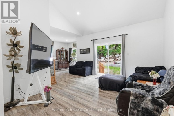 Living room with black sofas, vaulted ceiling, and a large television. - 316040 6 Highway, Chatsworth
