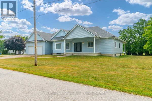 Hallway connecting to a modern kitchen with light blue cabinetry and stainless steel appliances. - 3167 Broadway Street, Brooke Alvinston