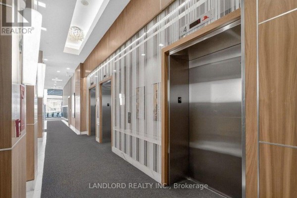 Interior hallway with stainless steel elevators, wood paneling, and decorative lighting. - 317 - 9506 Markham Road, Markham