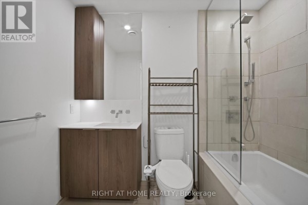 Bathroom with vanity, toilet, soaking tub, and glass shower enclosure. - 318 - 12 Bonnycastle Street, Toronto