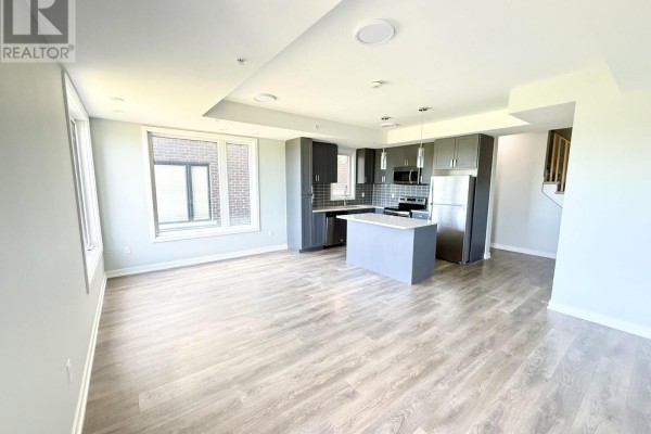 Open concept living room and kitchen with grey cabinets and island. - 318 - 1555 Kingston Road, Pickering