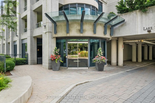 Exterior of a multi-story condo building with a circular driveway and fountain. - 318 - 2095 Lake Shore Boulevard W, Toronto