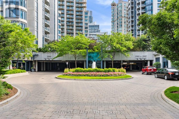 Outdoor common area with curved pathways, green grass, benches, and trees. - 318 - 2095 Lake Shore Boulevard W, Toronto