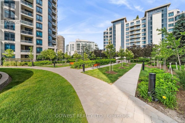 Large common room with seating, wood floors, and panoramic windows overlooking water. - 318 - 2095 Lake Shore Boulevard W, Toronto