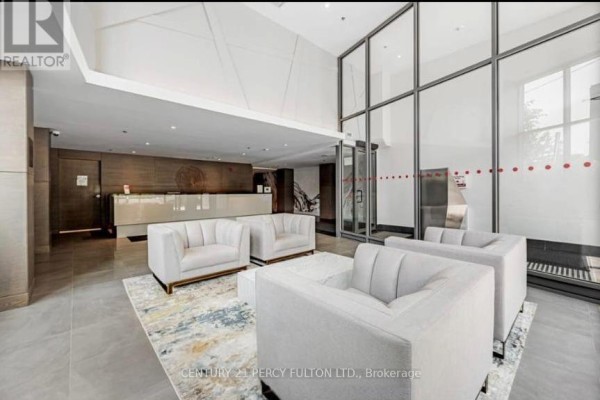 Building lobby with reception desk, seating area, and large glass windows. - 318 - 90 Glen Everest Road, Toronto