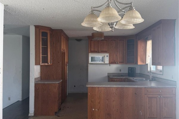 Living room with dark laminate flooring and a large bay window. - 318 25th Street E, Prince Albert