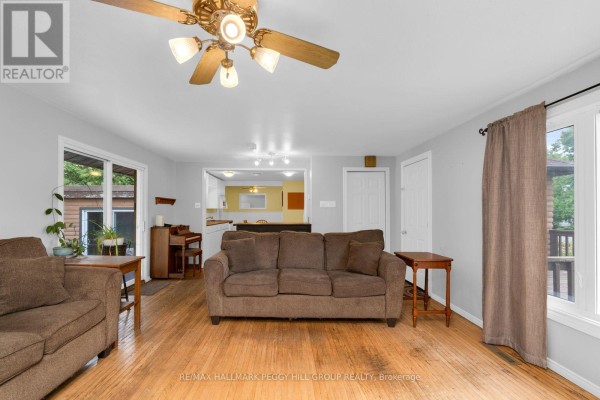 Living room with hardwood floors and a view into a kitchen and dining area. - 318 Percy Street, Tay