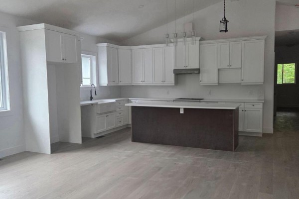 White kitchen with a dark brown island, white countertops, and subway tile backsplash. - 3183 Cove Avenue, Innisfil