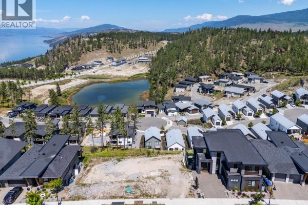 Vacant lot with a truck, overlooking a development and a distant lake with mountains. - 3183 Hilltown Drive, Kelowna